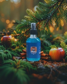 Aftershave Blue Wood Brodaty Ślązak na tle lasu, w otoczeniu zielonego jabłka, mchu i laski cynamonu – zdjęcie produktowe