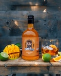 Aftershave Mango Brodaty Ślązak na tle drewna, otoczony świeżym mango, szklanką whisky, limonką i brzoskwinią – zdjęcie produktowe