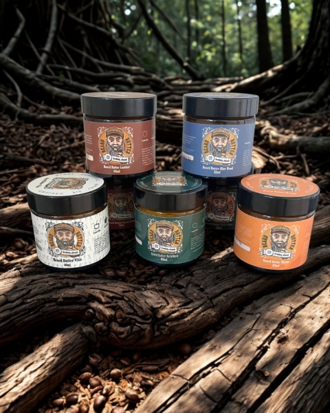 Wszystkie warianty maseł do brody Brodaty Ślązak ustawione na tle naturalnego krajobrazu – zielony las i leśne rośliny w tle